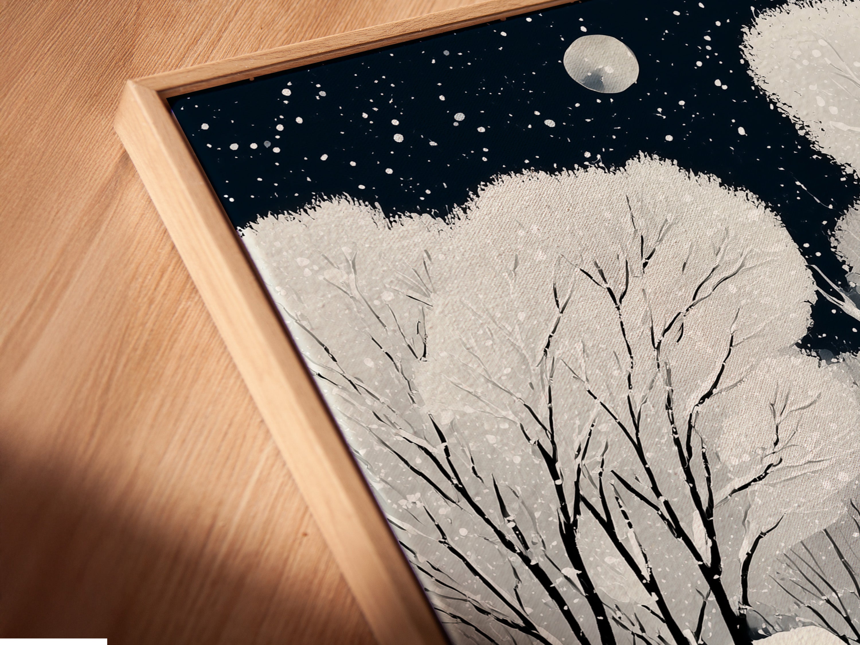 A close up angled view shows the Winter Village canvas print in a floating frame. This enhances the cozy snow scene wall art. The Scandinavian folk art is beautifully presented ready to elevate any space.