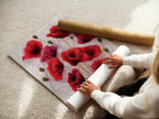 A woman is carefully rolling a fine art poster paper. This shows the care and quality of the botanical prints. Get ready to display your new crimson decor. Perfect for adding floral wall art to your space.
