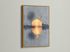 The sunrise reflection artwork is presented in a luxurious gold frame. The golden sun and abstract cityscape exude elegance. This modern wall art piece adds a touch of glamour to your home. A perfect choice for sophisticated decor.