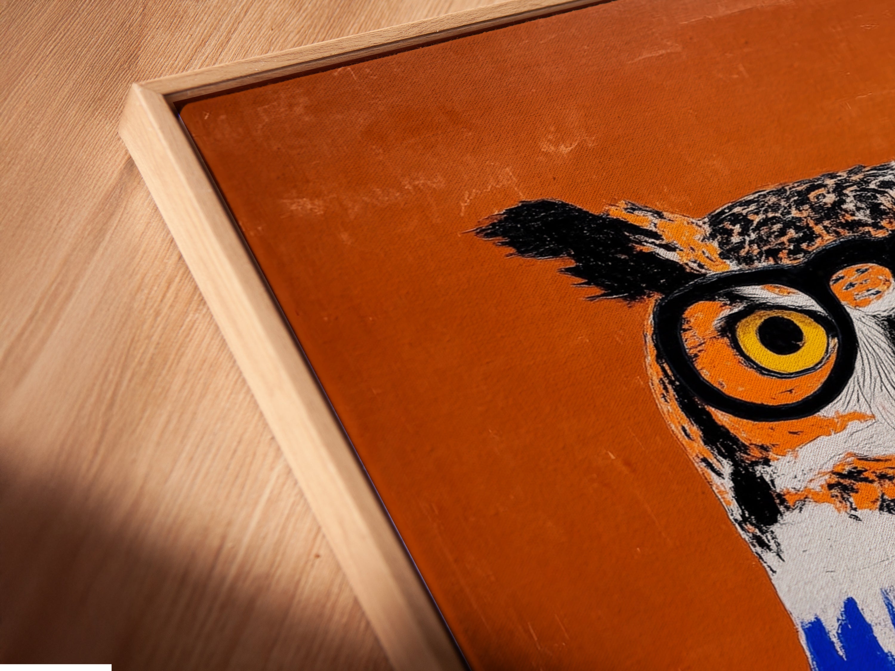A close-up of a canvas print in a floating frame. The Owl with Books Art Print is beautifully displayed. This is perfect for educators. It's also great for librarians and students. The book-themed art is captivating. Orange and blue colors pop.