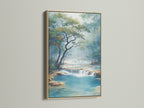 Waterfall Canvas artwork with an oak frame on a white wall. This nature canvas brings a serene landscape to any room. The turquoise river print adds a calming touch to your home decor. A perfect nature lover gift.