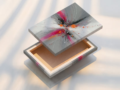 Stretched canvas print of Abstract Burst artwork featuring pink gray and orange tones. This contemporary explosion print is ready to hang. Perfect for adding a modern touch to your living room or office. The stretched canvas provides a gallery ready look. Enjoy this vibrant art in your space.