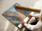 A woman carefully rolls a fine art poster paper of canyon artwork. This neutral tone landscape photography is perfect for any space. It's ideal for those seeking elevated modern wall art. The river gorge artwork adds a touch of nature.