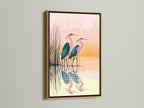 Heron bird artwork in a gold frame. The gold frame adds a touch of luxury to this coastal art piece. The pink and teal bird canvas print is elevated. Perfect for adding elegance to your nature-inspired decor.