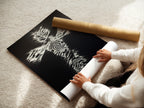 A woman is carefully rolling a fine art poster paper. The artwork is a Christian Cross Wall Art. This print features a zebra pattern cross. This is perfect for creating custom religious wall art. Ideal for Christians and art enthusiasts alike. It is a unique christian gift.