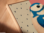 A close-up angled view of a canvas print in a floating frame. The Woodpecker bird artwork looks stunning. Its modern art print style adds a unique touch. The pink and blue colors blend seamlessly. A great piece for office wall art.