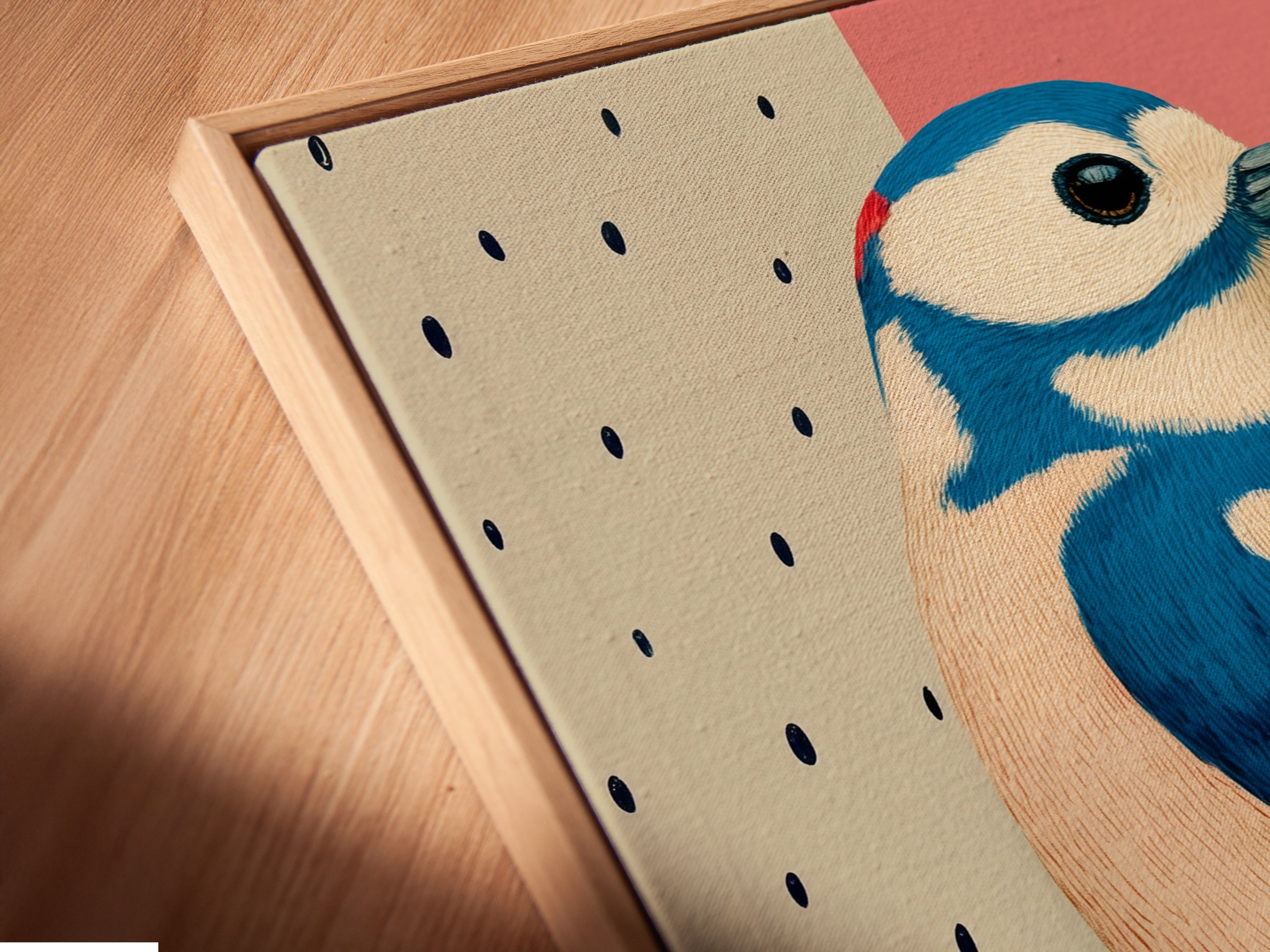 A close-up angled view of a canvas print in a floating frame. The Woodpecker bird artwork looks stunning. Its modern art print style adds a unique touch. The pink and blue colors blend seamlessly. A great piece for office wall art.
