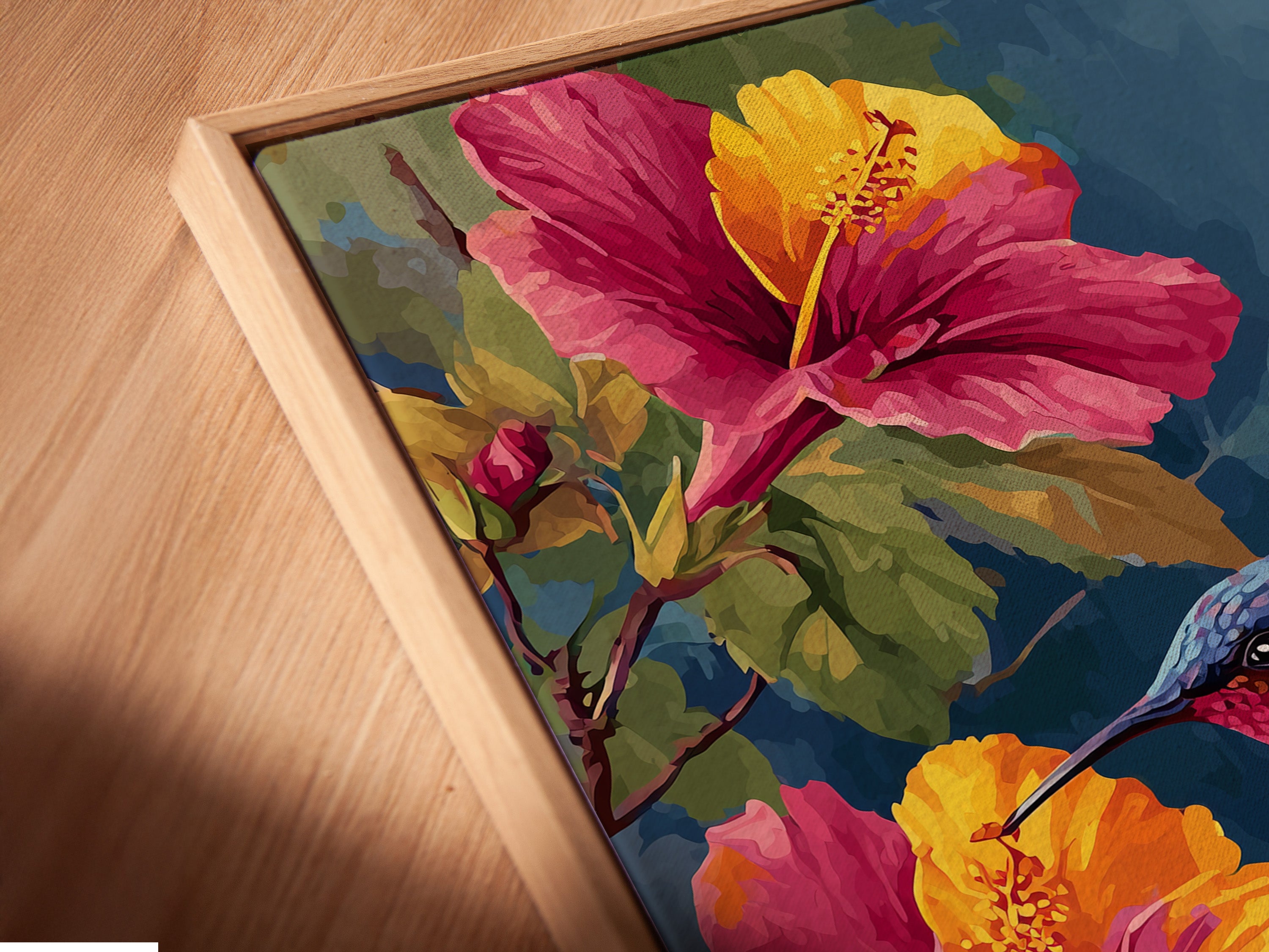 An angled close-up shows a canvas print in a floating frame. The artwork features a hummingbird with hibiscus flowers. The floating frame gives a modern gallery look. It makes the art stand out. Discover our unique framing options.