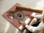 A woman rolls fine art poster paper. She is preparing Koala Wall Art for printing. This trendy animal canvas print will become modern art for nurseries and kids' rooms. The paper ensures a high-quality finish.