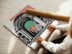 A woman carefully rolls a fine art poster paper of the New York Arch. This high-quality poster captures the essence of the cityscape print. Perfect for framing or displaying as is. Explore fine art poster options for your decor