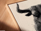 A close-up angled view of a canvas print in a floating frame. The bull artwork features a modern halftone print. The floating frame adds depth and dimension. This unique framing style enhances the artwork's contemporary look. It's perfect for creating a gallery-like feel in your home or office. Elevate your wall art today.