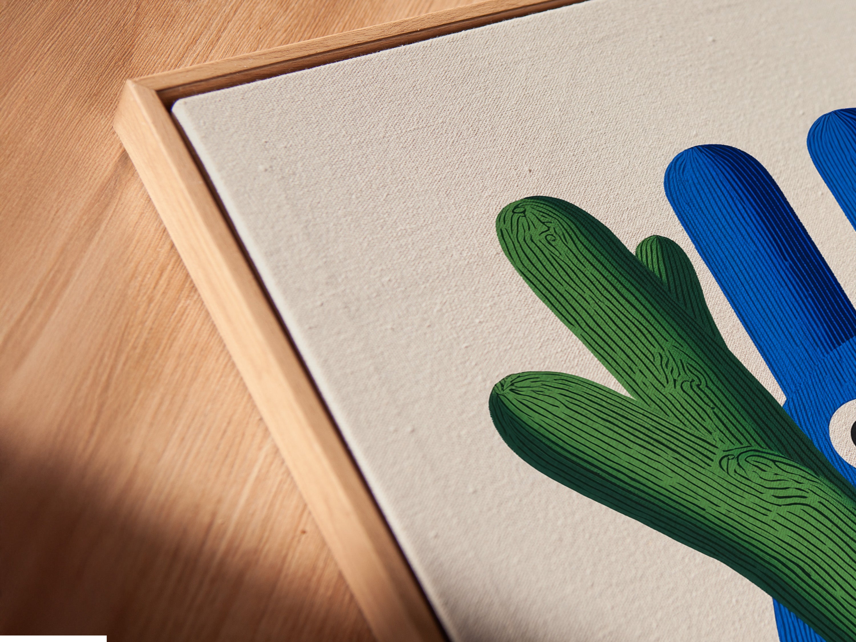 A close-up angled view of a canvas print in a floating frame. The whimsical cactus artwork looks stunning. It is a great way to display kids room art. This blue green nursery wall decor is both contemporary and playful. It is perfect for children.