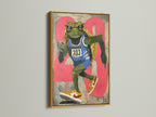 A frog runner art print is elegantly displayed in a gold frame. This sports wall art piece adds a touch of retro style. The urban street art canvas is perfect for a teen room. It serves as great fitness art. The artwork's primary color is green with secondary pink accents. It is perfect for youth rooms.