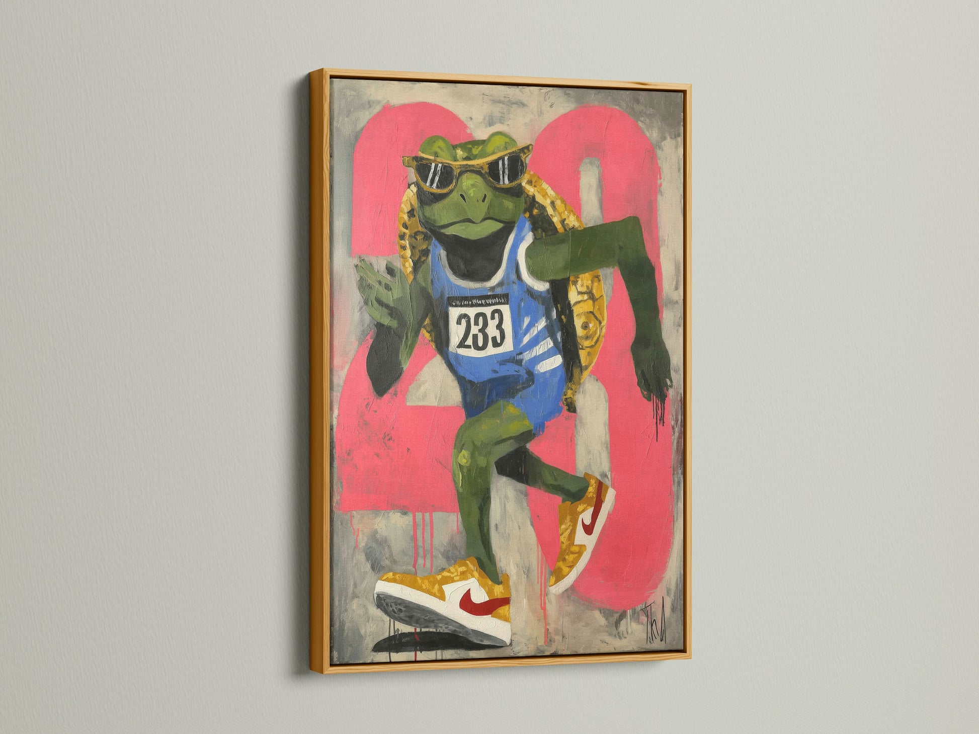 A frog runner art print is elegantly displayed in a gold frame. This sports wall art piece adds a touch of retro style. The urban street art canvas is perfect for a teen room. It serves as great fitness art. The artwork's primary color is green with secondary pink accents. It is perfect for youth rooms.