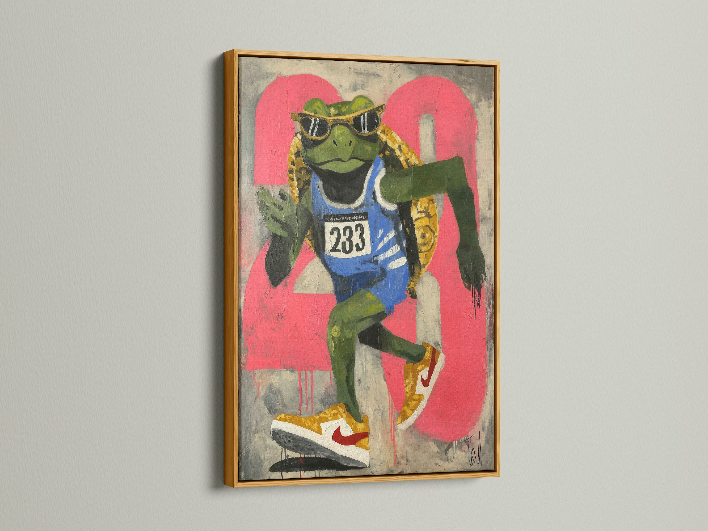 A frog runner art print is elegantly displayed in a gold frame. This sports wall art piece adds a touch of retro style. The urban street art canvas is perfect for a teen room. It serves as great fitness art. The artwork's primary color is green with secondary pink accents. It is perfect for youth rooms.