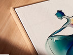 Close-up angled view of a canvas print in a floating frame. The artwork features an abstract ballet dancer in watercolor. The blue and orange colors create a modern look. Ideal for dance studio decor and contemporary wall art.