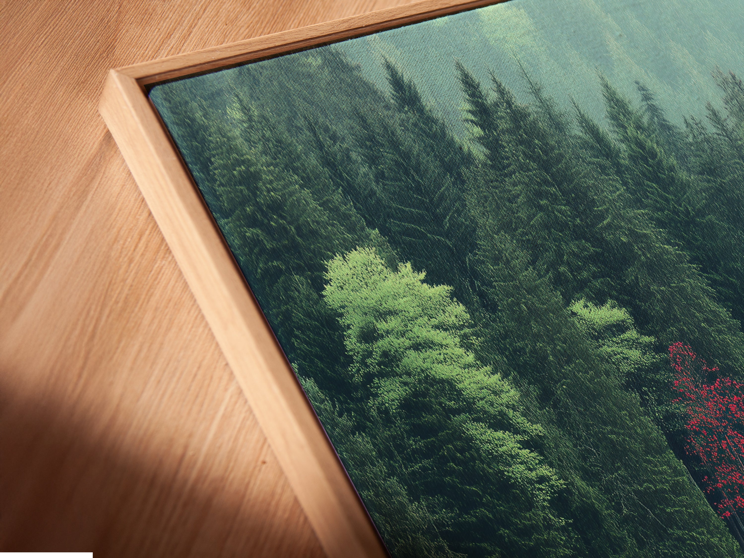 A close-up angled view reveals a canvas print of the Lakeside Cabin artwork in a floating frame. The artwork shows a detailed view of the cabin by the lake and forest. The floating frame enhances the modern aesthetic. Ideal for those seeking elevated forest landscape art.