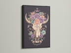 Artwork of a floral bull skull in a black frame. The art print features a skull adorned with colorful roses. This artwork is framed in a modern black frame. The black frame makes the artwork pop. Perfect wall art for any space.