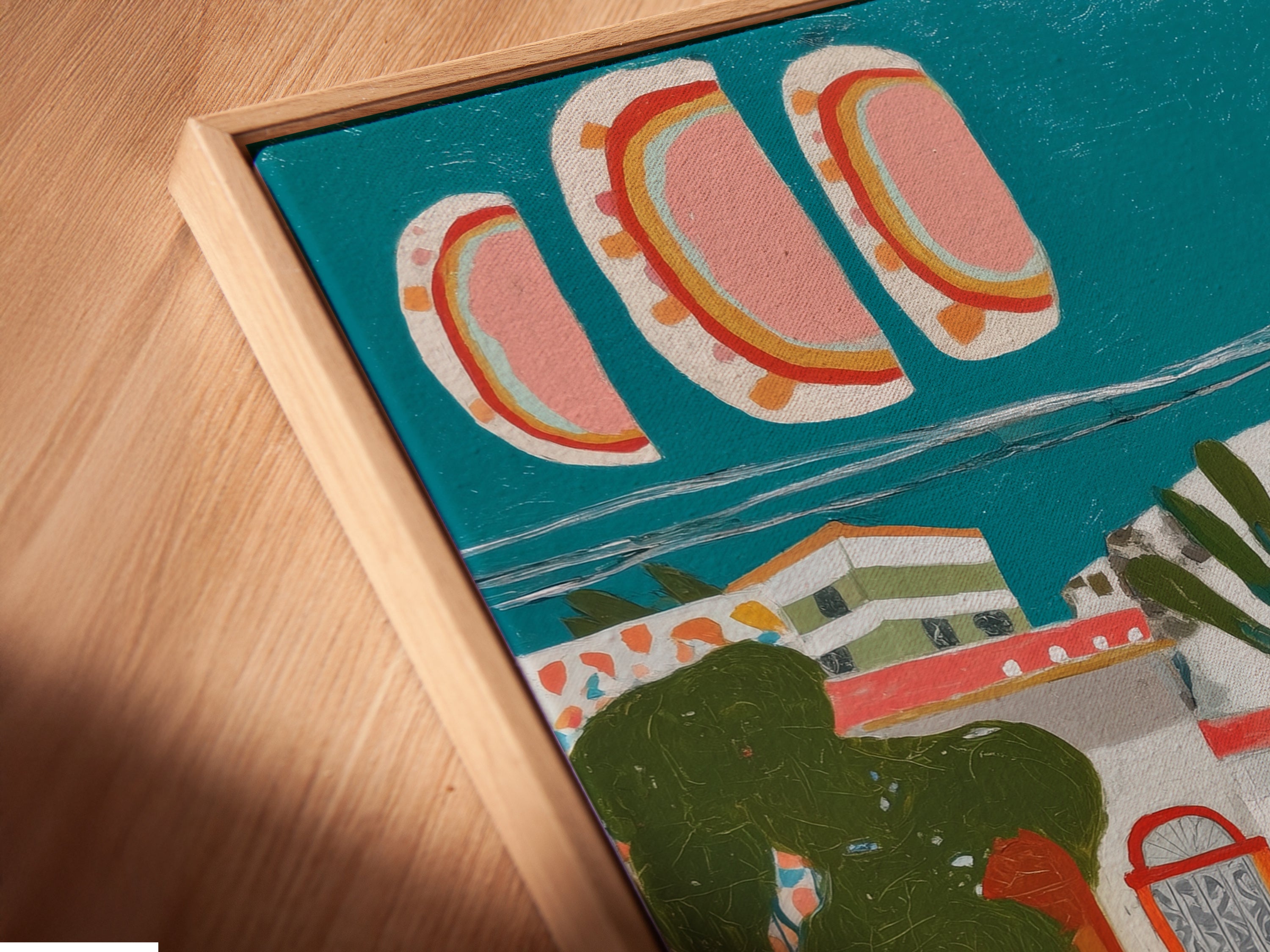 A close-up angled view of a canvas print in a floating frame. This art features a Mediterranean village and vintage car. The floating frame gives the artwork a modern sophisticated look. This is ideal for showcasing coastal and tropical artwork.