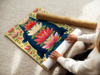 A woman carefully rolls a fine art poster paper featuring the Alligator artwork. The botanical print showcases teal and coral colors. Perfect for creating unique wall art this poster paper allows for customizable framing. Bring exotic artwork to your home with this option.