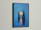A black frame highlights this sailboat art. The nautical print features navy blue sailboats and a sunset. It is perfect as coastal wall art. Elevate your living room or bedroom decor. It suits minimalist Scandinavian or coastal styles. This artwork is a stylish choice.