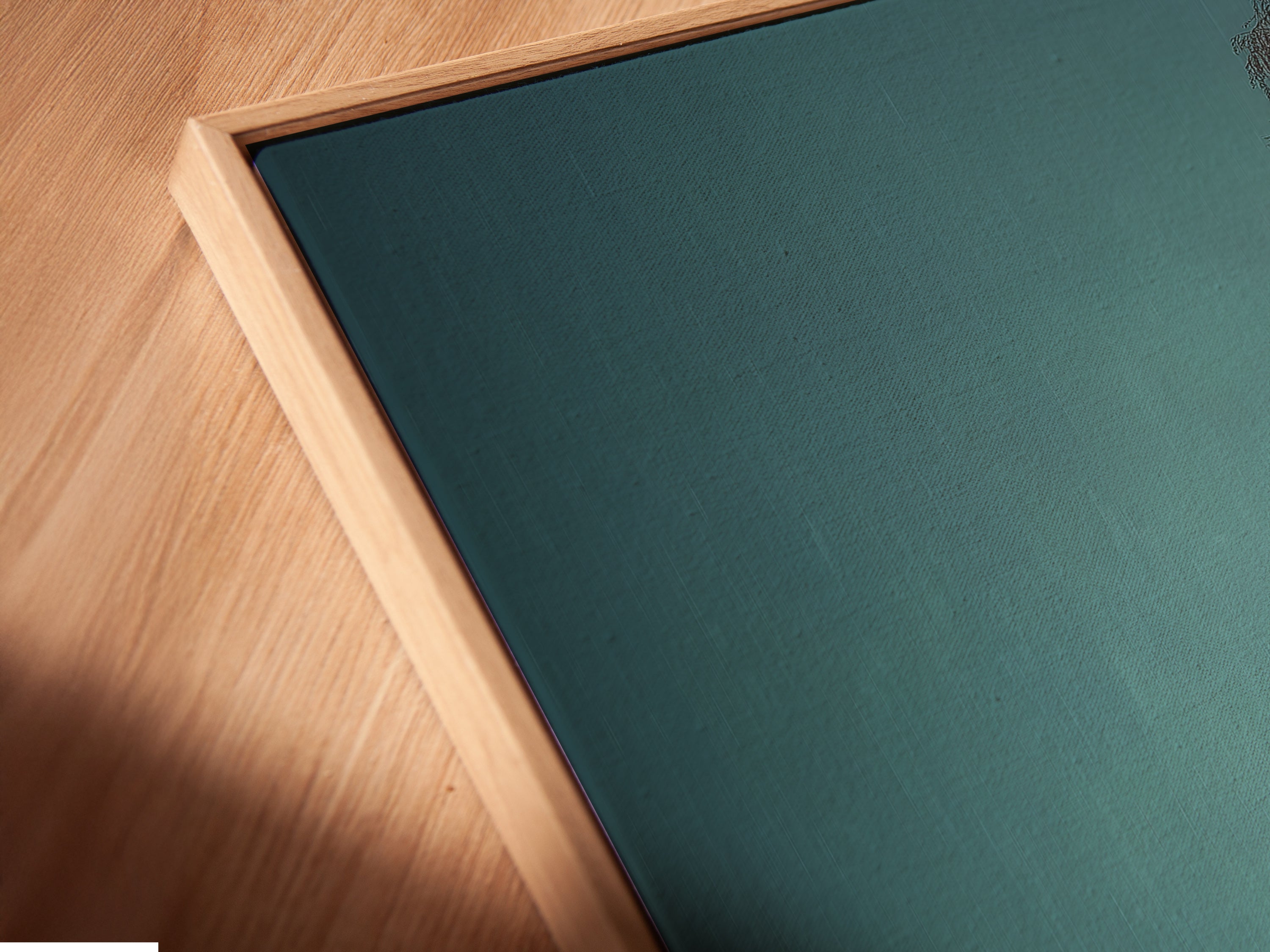 A close-up angled view of a canvas print in a floating frame. The artwork depicts a moody lake landscape ideal for cottagecore decor. The floating frame enhances the artwork's modern appeal. Perfect for adding a touch of nature and elegance to your living space. A beautiful cabin artwork.