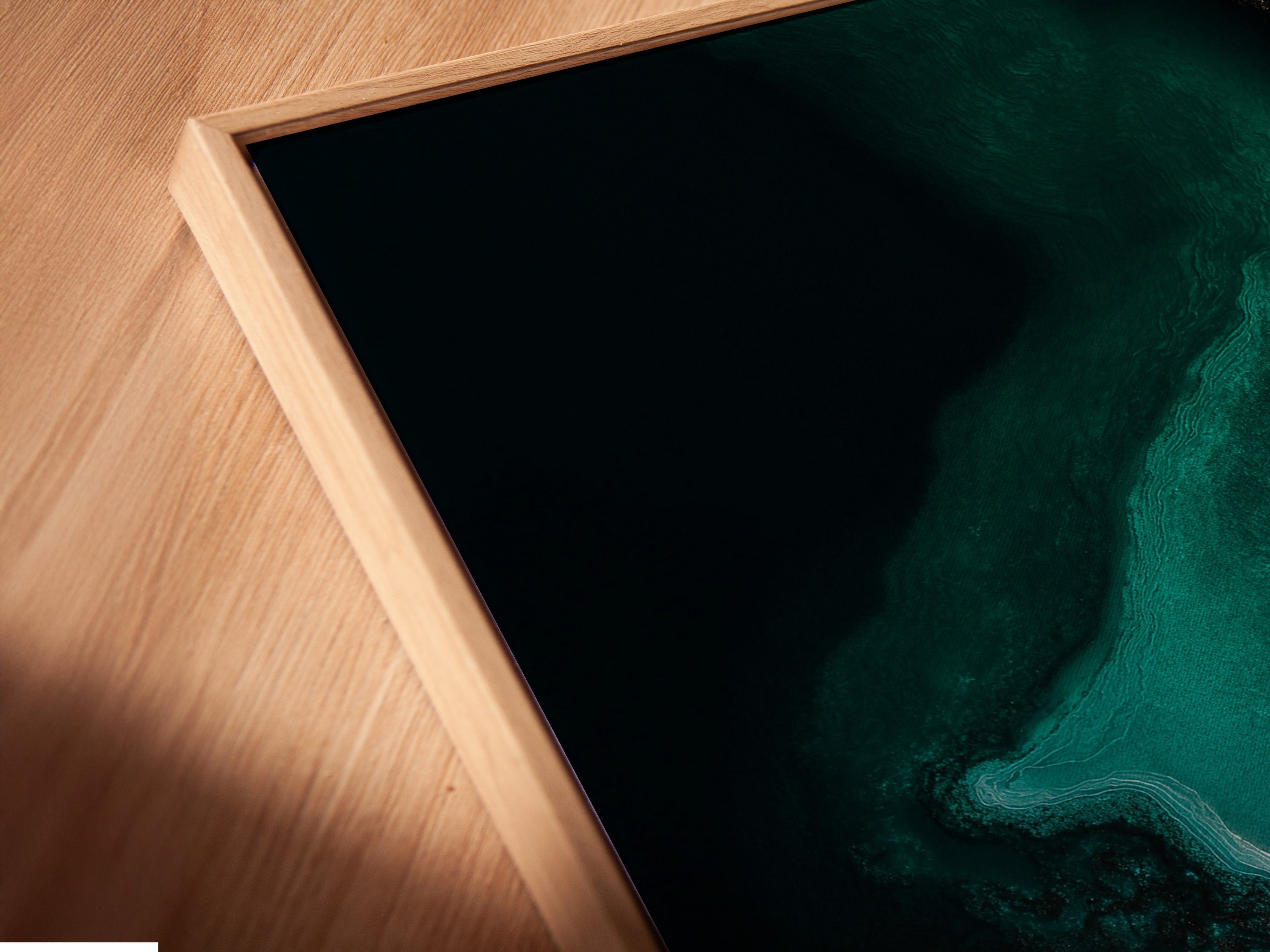 Close-up shot of a canvas print in a floating frame. The artwork displays vibrant emerald green and gold tones. The floating frame gives a gallery-like appearance. The frame enhances depth and dimension. A modern way to display your favorite artwork.