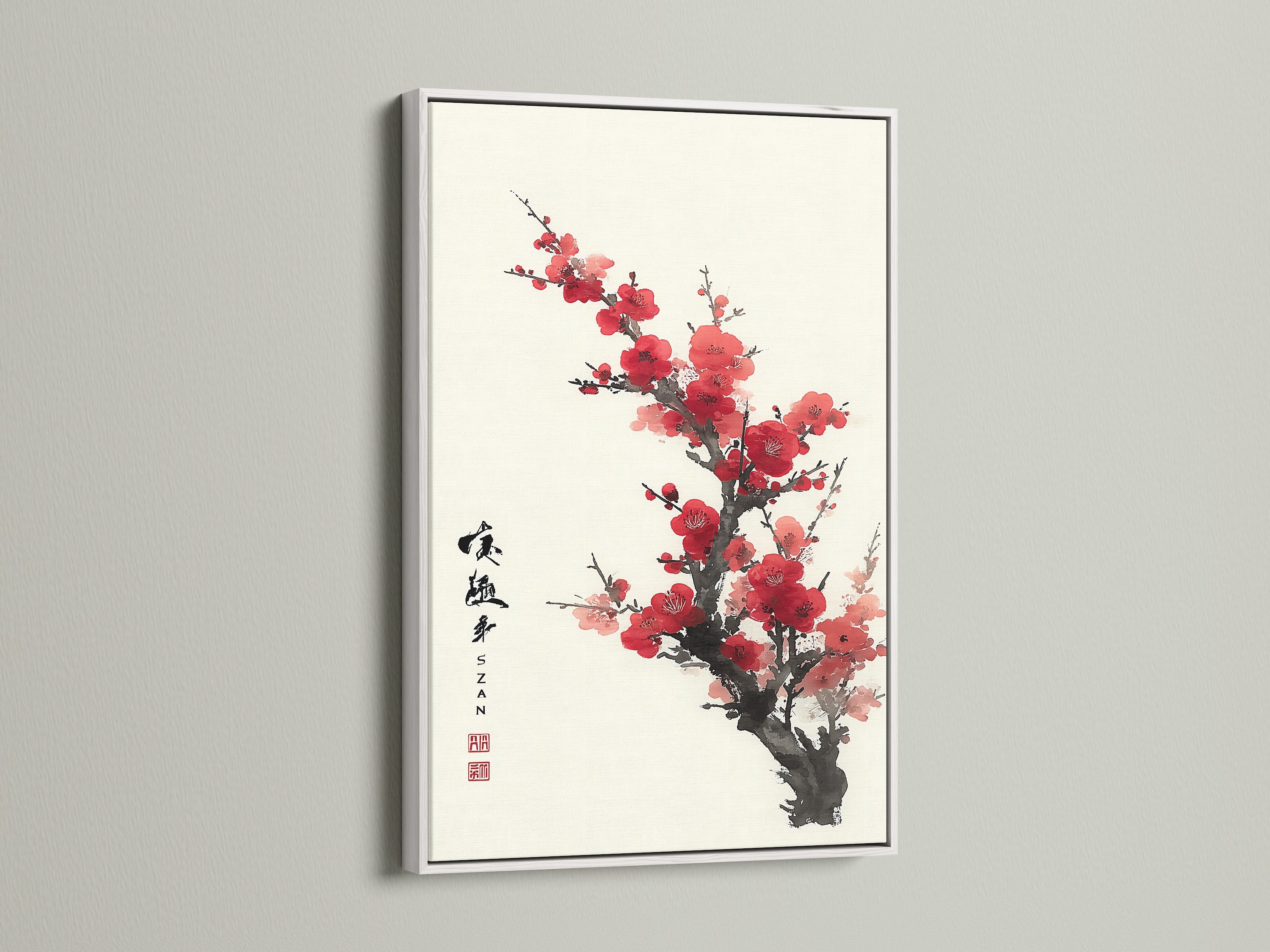 Artwork featuring red blossoms in a white frame. The light frame highlights the artwork. It is hung on a white wall. The colors pop beautifully in this piece. Elevate your home decor with framed artwork. A simple way to add personality to your space.