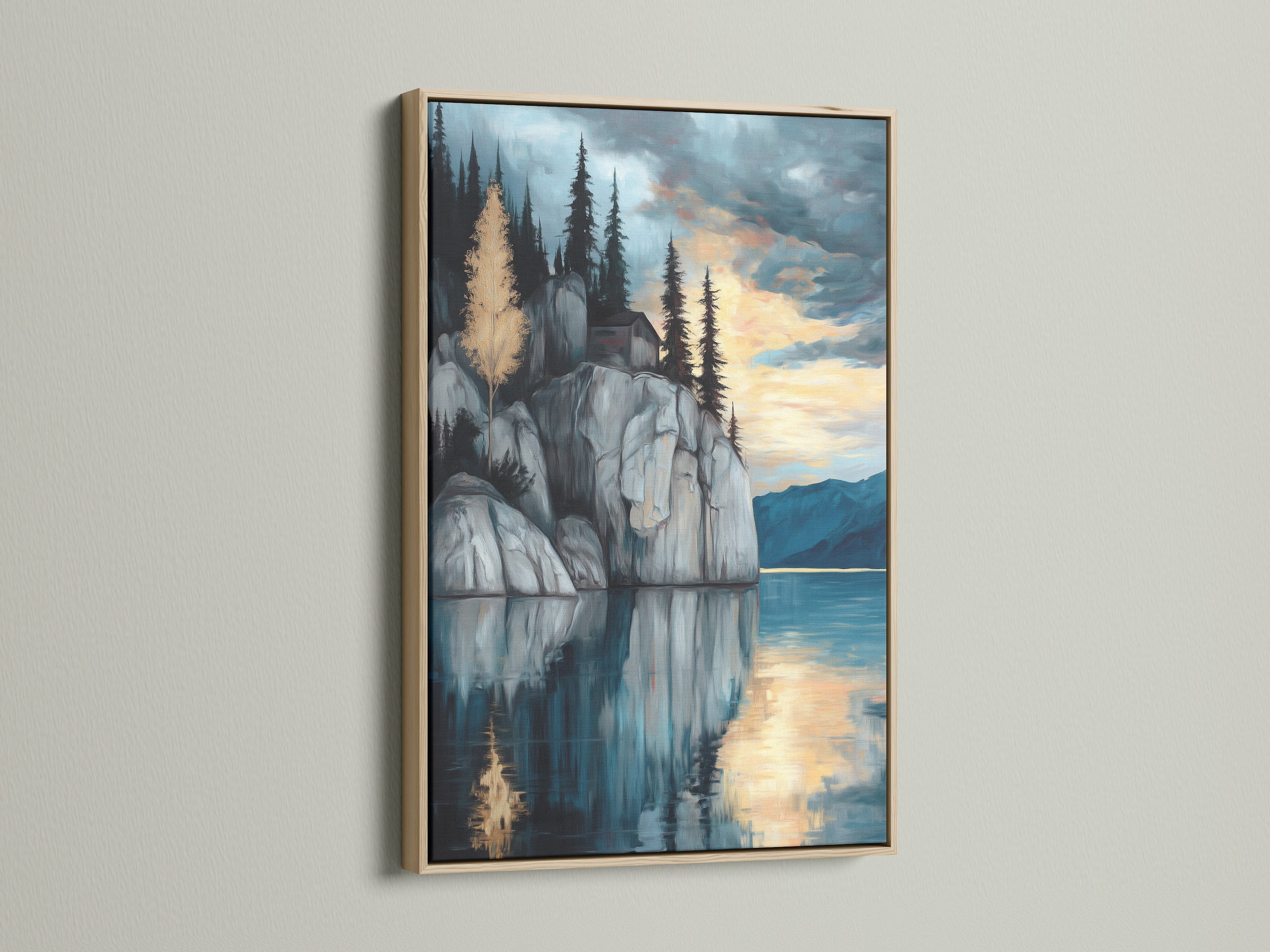 Lakeside Cliff canvas print with an oak frame. A serene mountain wall art piece perfect for study room decor. This moody landscape artwork showcases a tranquil scene. Blue and gray hues create a reflective art piece. The mountain painting and water reflection enhance this scenic art print.