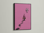 Surreal pink artwork in a black frame. The art features a figure walking away with suitcases. This minimalist canvas print adds a contemporary touch to any office decor. It's a modern abstract poster. The artwork suits Scandinavian styles.