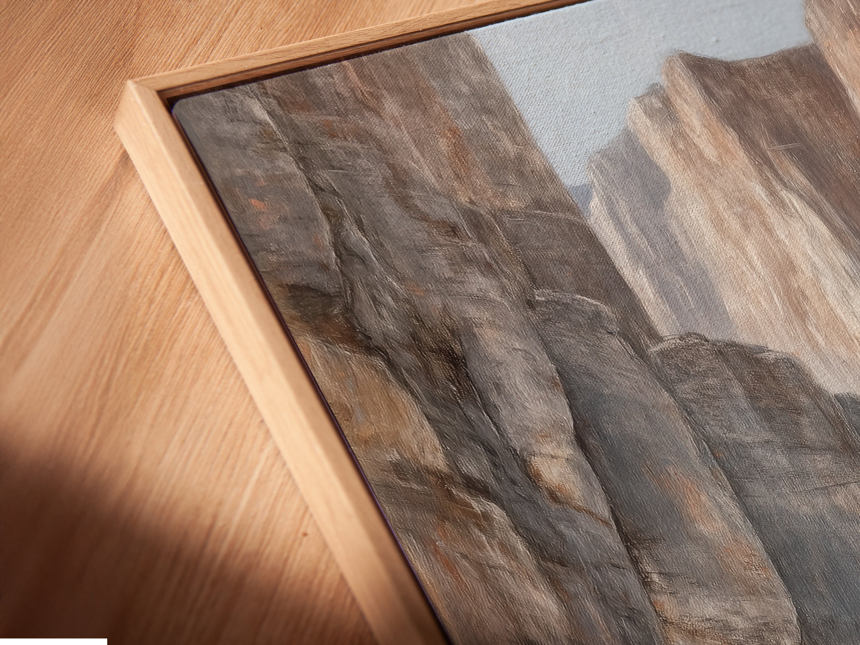 A close-up angled view of a Canyon River canvas print in a floating frame. This desert landscape artwork appears to float on the wall. Neutral tones and a floating frame create a modern look. Ideal for showcasing earth tone art. Explore the beauty of this nature painting. Perfect for any room.