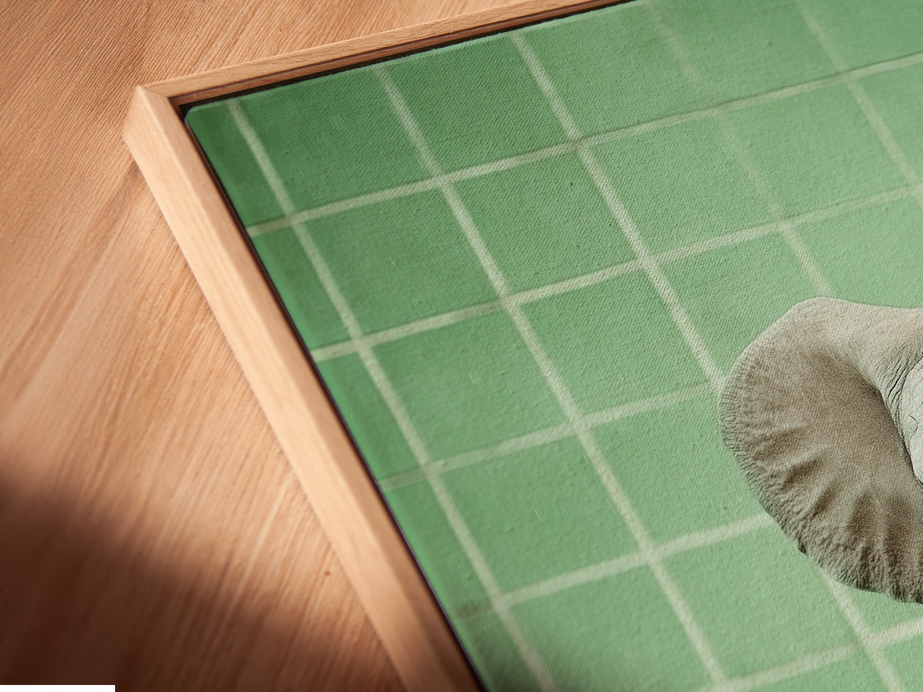 Close up angled view of a Baby Elephant canvas print in a floating frame. The floating frame gives the artwork a gallery like feel. This fine art print is perfect for a neutral tone nursery. Decorate with style and sophistication.