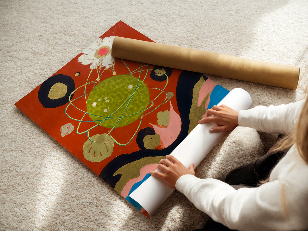 A woman rolls a fine art poster paper. This cosmic abstract art print is a celestial collage. It is modern surreal artwork. This planetary art features space wall art. This vibrant wall art will elevate any space.