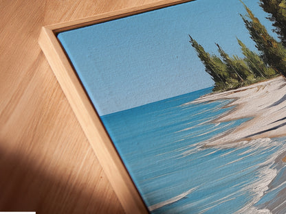 Close-up of a Canvas Print in a Floating Frame. The artwork features a detailed ocean view with a sandy shoreline. This adds a modern touch to coastal cottage art. Perfect for elevated coastal decor.