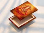 A stretched canvas print displays Ganesha artwork. The Hindu God wall art is in golden orange spiritual tones. This piece is ideal for meditation rooms and yoga studios. It adds a vibrant touch to any space.