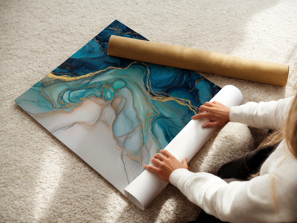 A woman carefully rolls a fine art poster paper. The paper features a captivating blue abstract artwork. The fluid acrylic texture and gold accents add a touch of luxury. This poster is perfect for modern bedroom decor. Ideal for those seeking elevated contemporary wall decor.