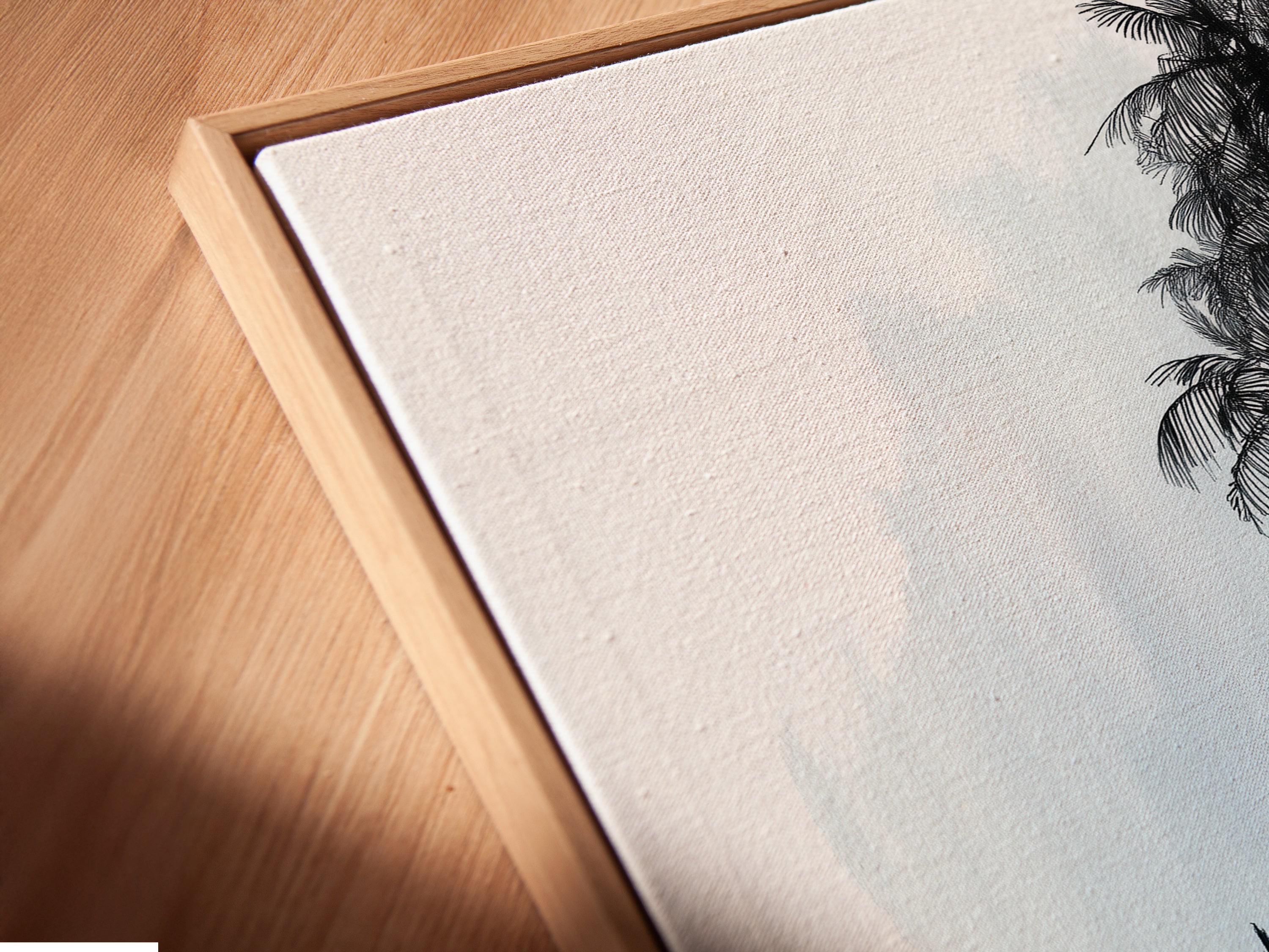 A close up angled view reveals a canvas print in a floating frame. The minimalist seascape artwork features a sailboat and sunlit tree. The floating frame enhances the art adding depth and sophistication. Perfect for coastal or minimalist decor. Explore our range of framed art prints for your home or office.