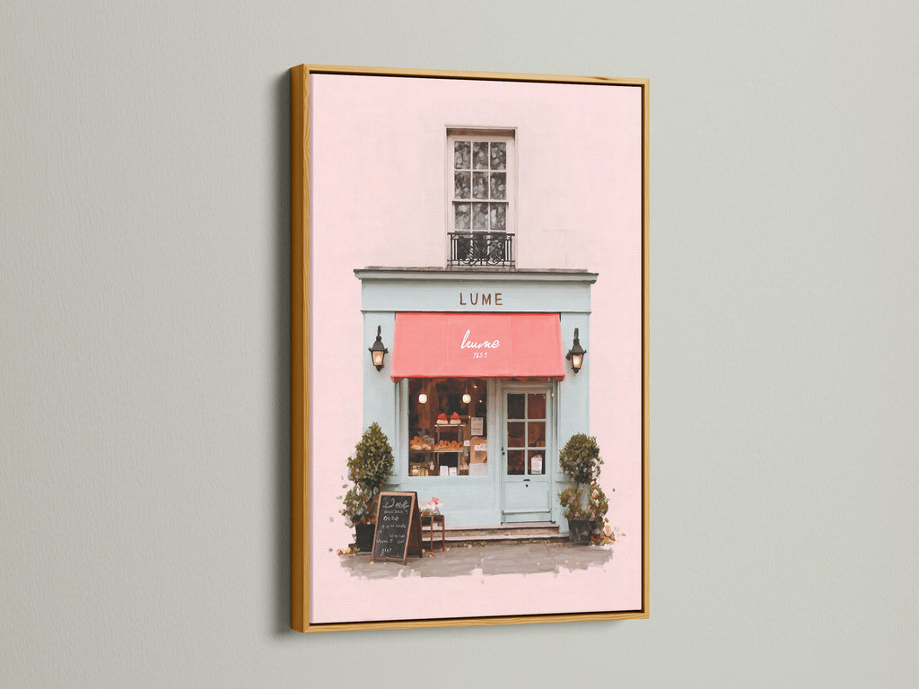 This beautiful art print is presented in a luxurious gold frame. The artwork features a charming building with a pink exterior and a vibrant red awning. The gold frame adds a touch of opulence and glamour. The piece enhances the artwork’s beauty. It is Ideal for adding a touch of luxury to your decor.