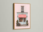 This beautiful art print is presented in a luxurious gold frame. The artwork features a charming building with a pink exterior and a vibrant red awning. The gold frame adds a touch of opulence and glamour. The piece enhances the artwork’s beauty. It is Ideal for adding a touch of luxury to your decor.