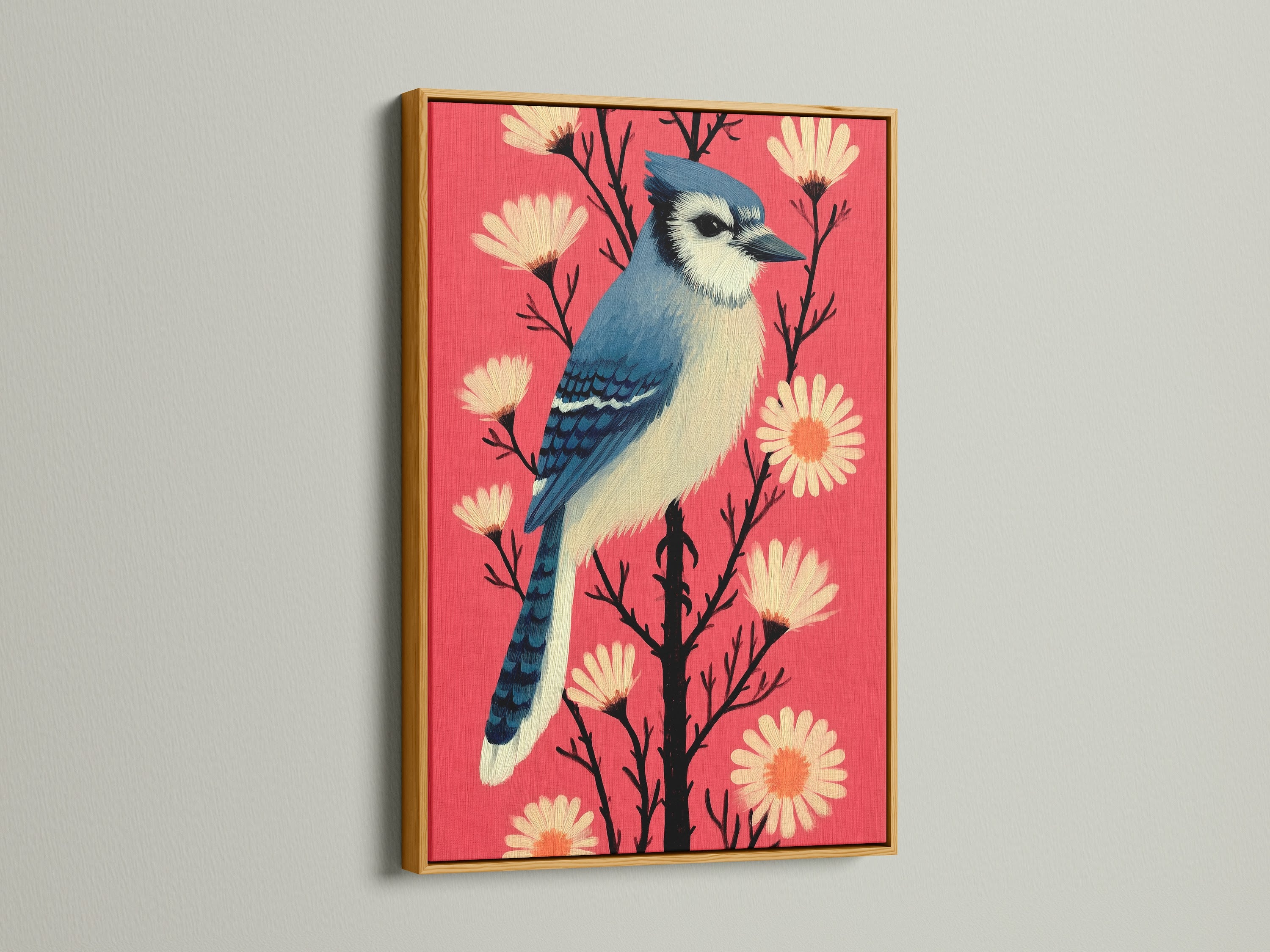 A vibrant blue jay art print in a gold frame. The artwork features a beautiful blue jay bird and coral pink flowers. The gold frame adds a touch of luxury. This bird canvas print is ideal for living room wall art.