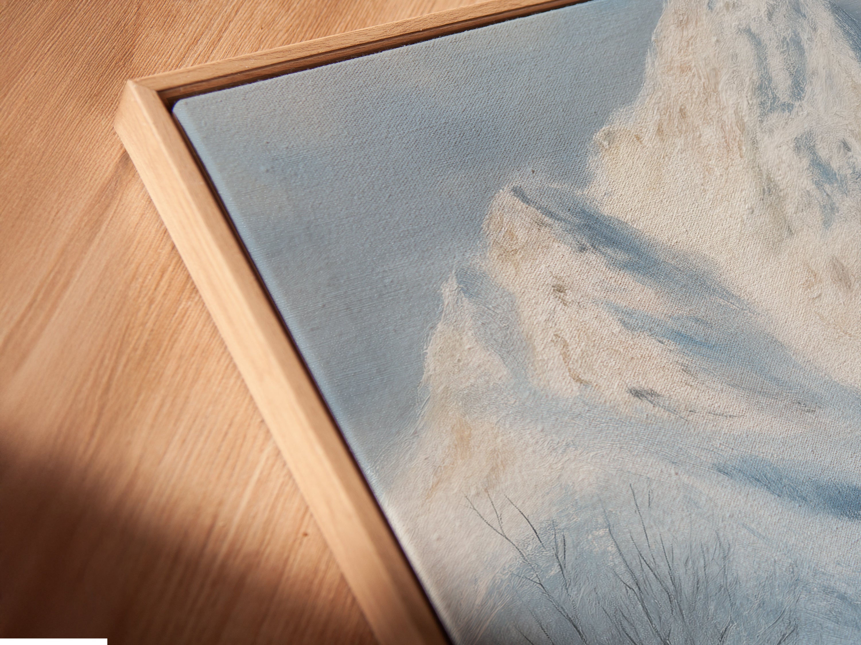 Angled close-up reveals the textured beauty of a canvas print in a floating frame. The snowy landscape wall art brings rustic artwork to life. Perfect farmhouse decor for a cabin. Experience the depth and detail of fine art.