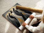 A woman is carefully rolling a fine art poster paper. The paper features the abstract hooded figures artwork. It is a spiritual decor piece. The poster is ready for framing and display in your home or office.