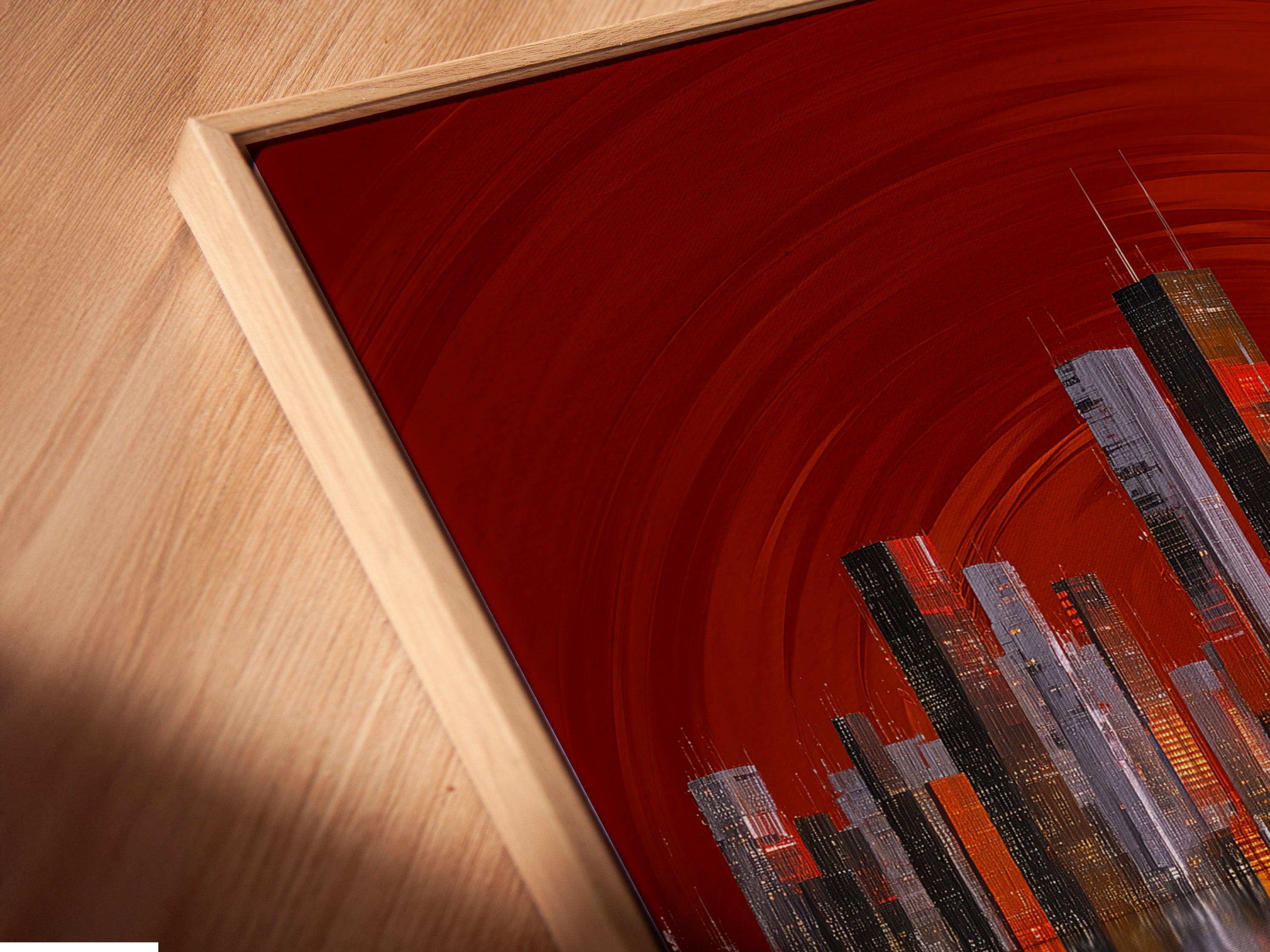 A close-up angled view reveals a canvas print in a floating frame. The city skyline artwork features red abstract urban elements. This modern cityscape wall art enhances any room. Ideal for architectural artwork.