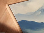 Close-up of a canvas print in a floating frame showcasing a mountain valley landscape. This butterfly artwork offers a unique farmhouse style. This nature wall decor is perfect for any room. The mountain vista and wildflower art create a serene atmosphere. Ideal rustic wall art for country home decor.