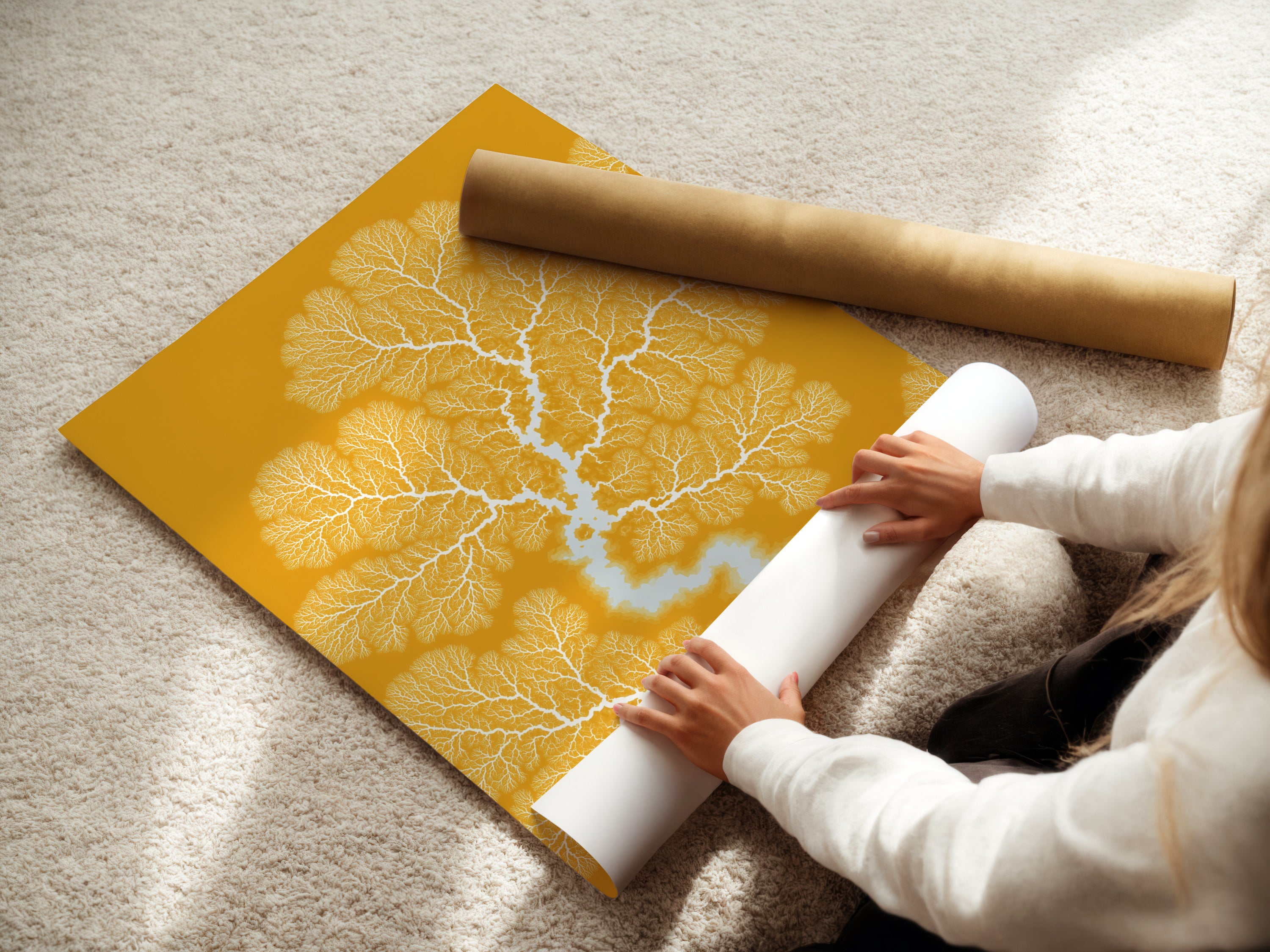 A woman carefully rolling a fine art poster paper featuring a Botanical Fractal Print. The mustard yellow artwork showcases abstract branch art. It’s ideal for homeowners seeking unique and affordable wall decor to enhance their living spaces.