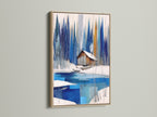 Winter Cabin Canvas Artwork with an oak frame. A serene snowy lake is depicted in this wall art. This piece is perfect for chalet decor. The oak frame adds a rustic touch to the blue and white abstract winter art. A modern wall art choice for nature print lovers and lake house decor.