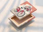 This is a stretched canvas print. A vintage bicycle with coral pink flowers is featured. This whimsical botanical art is perfect for any room. The stretched canvas adds texture and depth. This artwork will enhance your home decor.