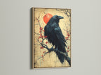 Raven Canvas Print with an oak Frame. This Japanese art wall decor features a bird on a cherry blossom branch. Ideal as a gothic print or dark academia artwork. Enhance your office art with this crow artwork.
