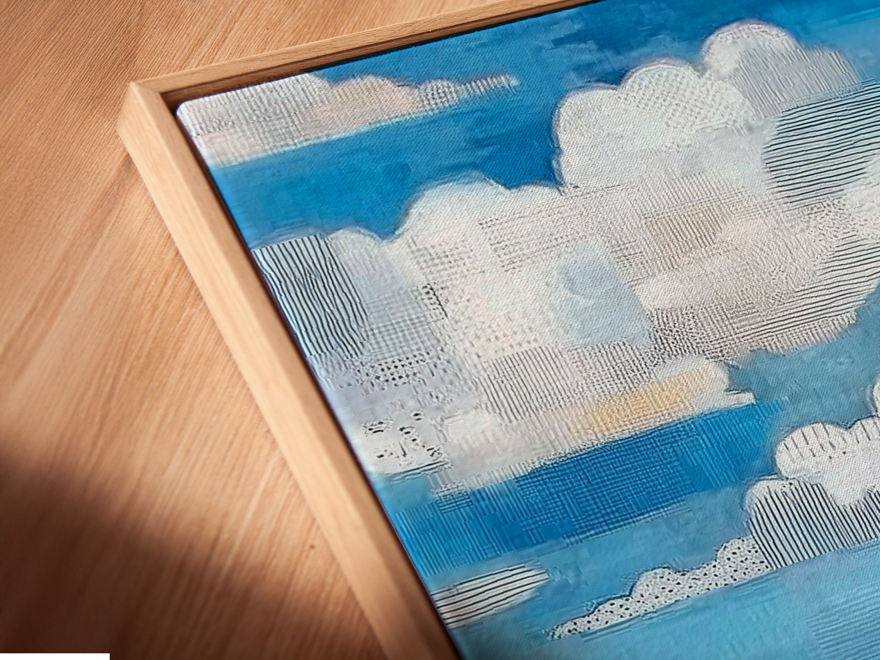 Close up of a canvas print in a floating frame. The artwork is a coastal beach scene. It features colorful beach houses and a turquoise ocean. The floating frame enhances the art.