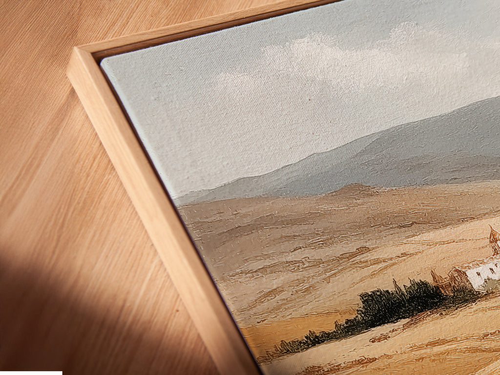 Angled close up of a Tuscan Landscape canvas print in a floating frame. The Italy countryside wall art features a farmhouse with neutral tones. This piece enhances any farmhouse decor. The Italian scenery captures the essence of a wheat field. Perfect rustic wall art for any room.